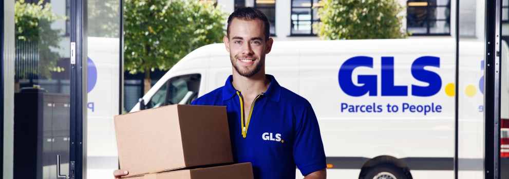 Un livreur tient un colis devant sa camionnette